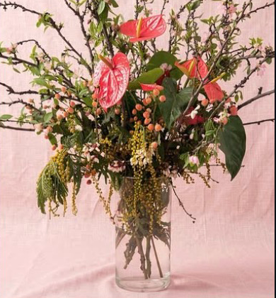A tall spring arrangement of branches and anthurium
