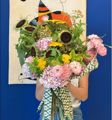 A bouquet held up in front of a painted cloth