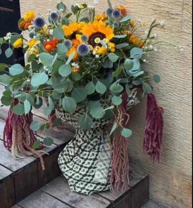 Sunflowers, thistle and eucalyptus wrapped in printed cloth